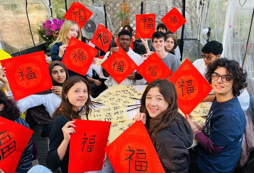 Students learning Chinese calligraphy in Beijing, creating their own "Fu" characters for good fortune