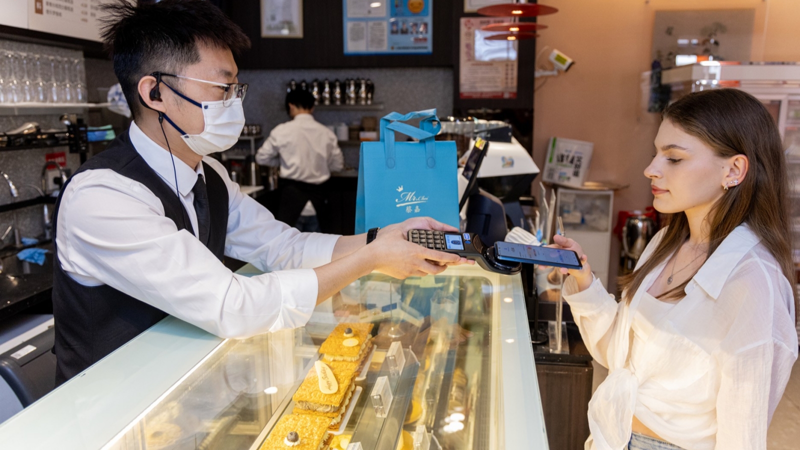 A tourist paying with Alipay at a bakery in China.