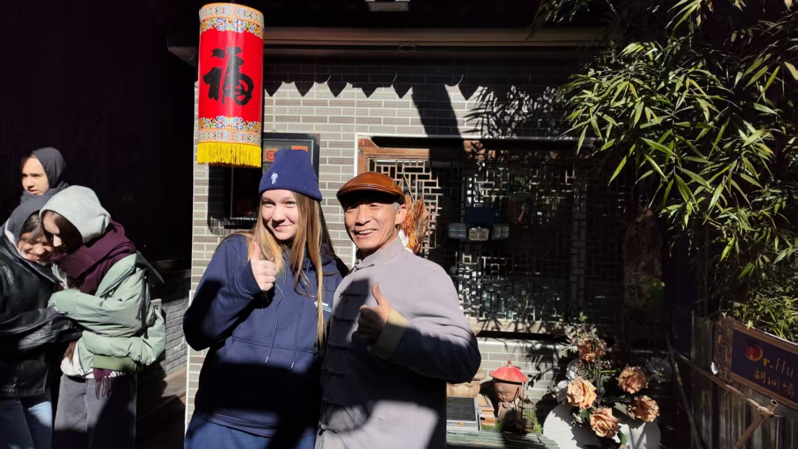 Students posing with their calligraphy workshop teacher in a Beijing hutong.